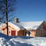 norwegische Holzhütte mit schneebedecktem Dach